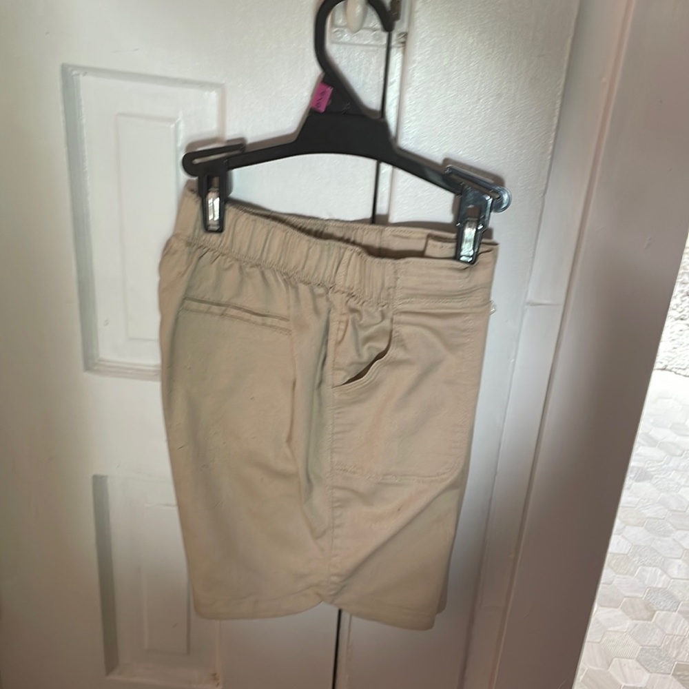 These are unisex beige shorts intended for school